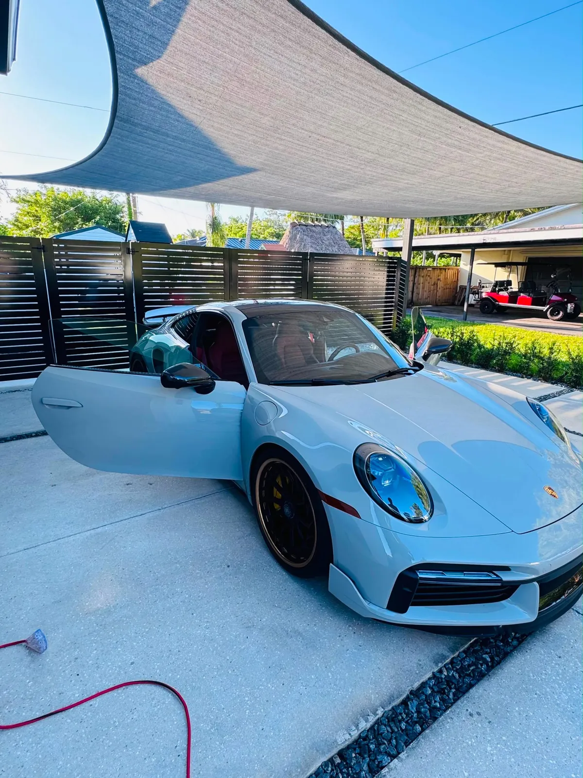 White Porsche 911 with the door open after a full detail