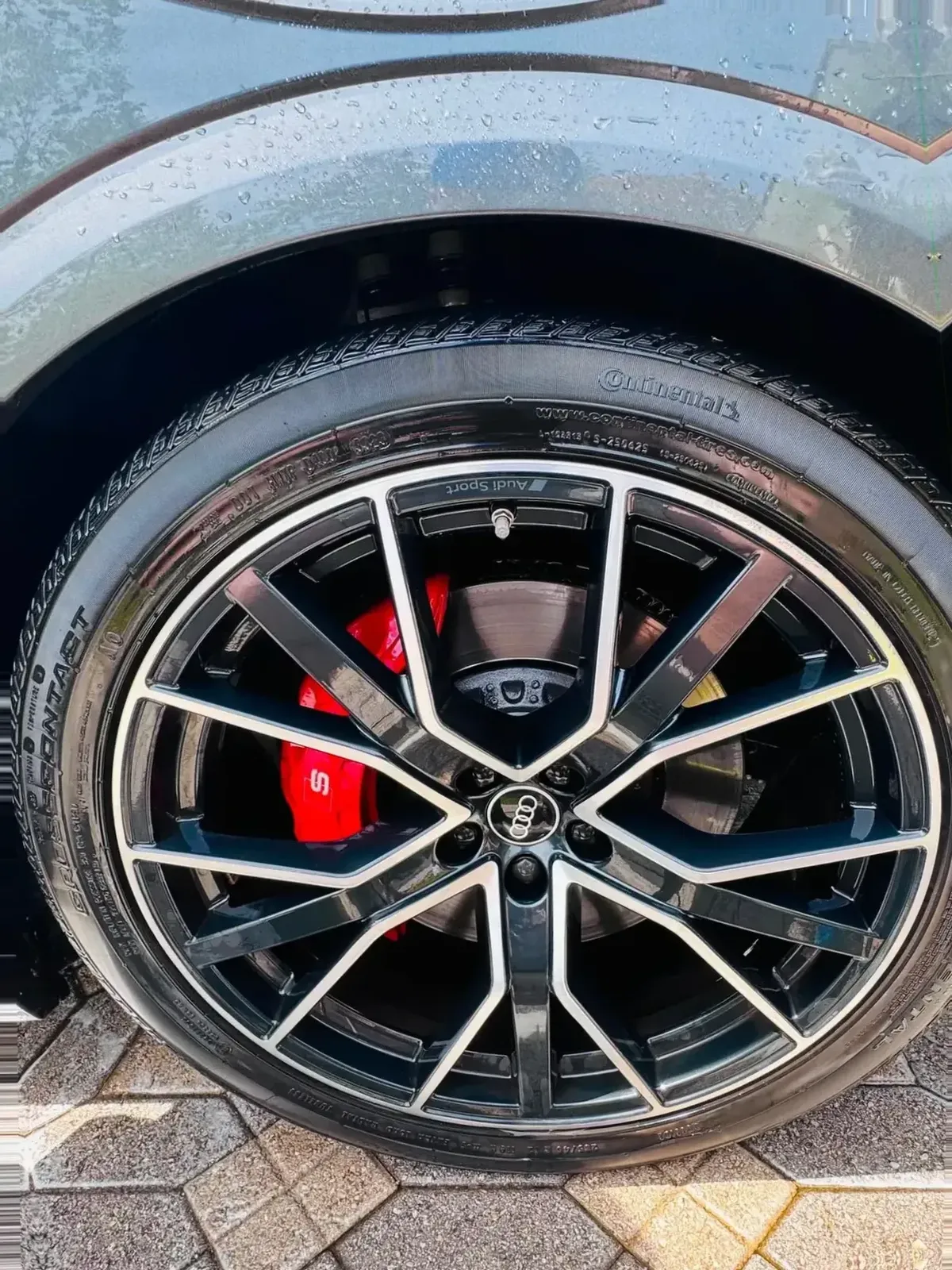 The same Audi wheel after detailing, glossy with a clean dressed tire